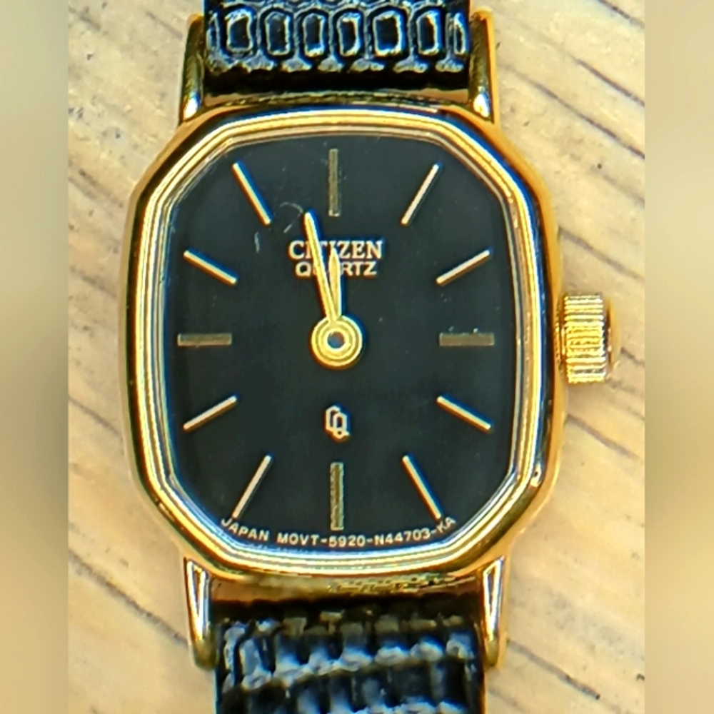 X Citizen Quartz Gold tone case hour markers and hands. Black reptile leather b